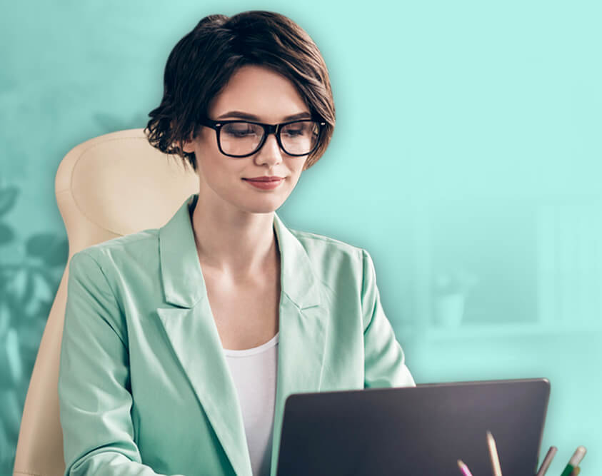 A corporate woman working on a laptop.